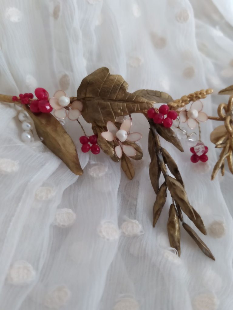 Tocado Marchessa , un tocado estiloso para novias con aire vintage. Combinando diferentes tipos de flores y hojas en oro viejo